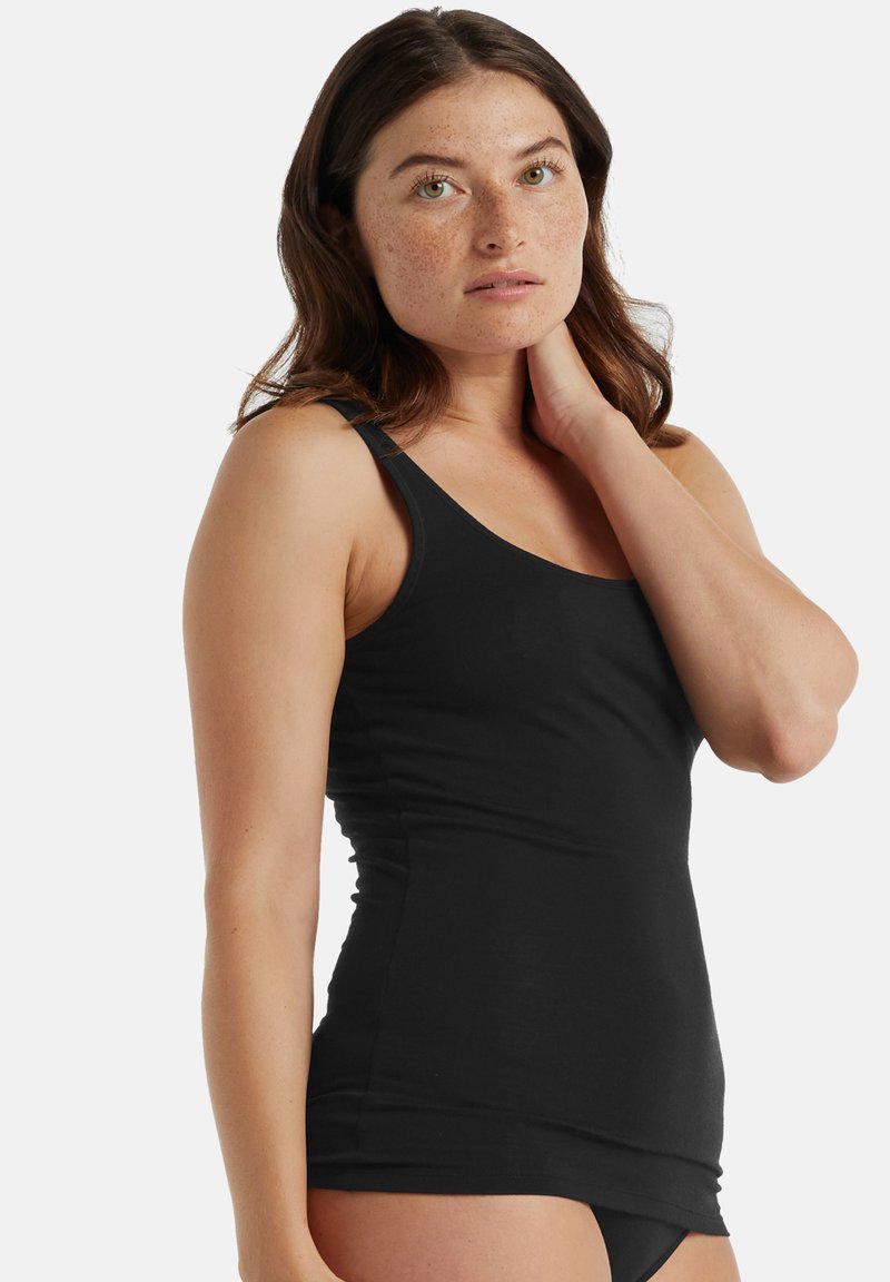 Canotta nera realizzata in tessuto morbido e elastico con spalline sottili e un design aderente, caratterizzata da una texture liscia e una silhouette semplice.