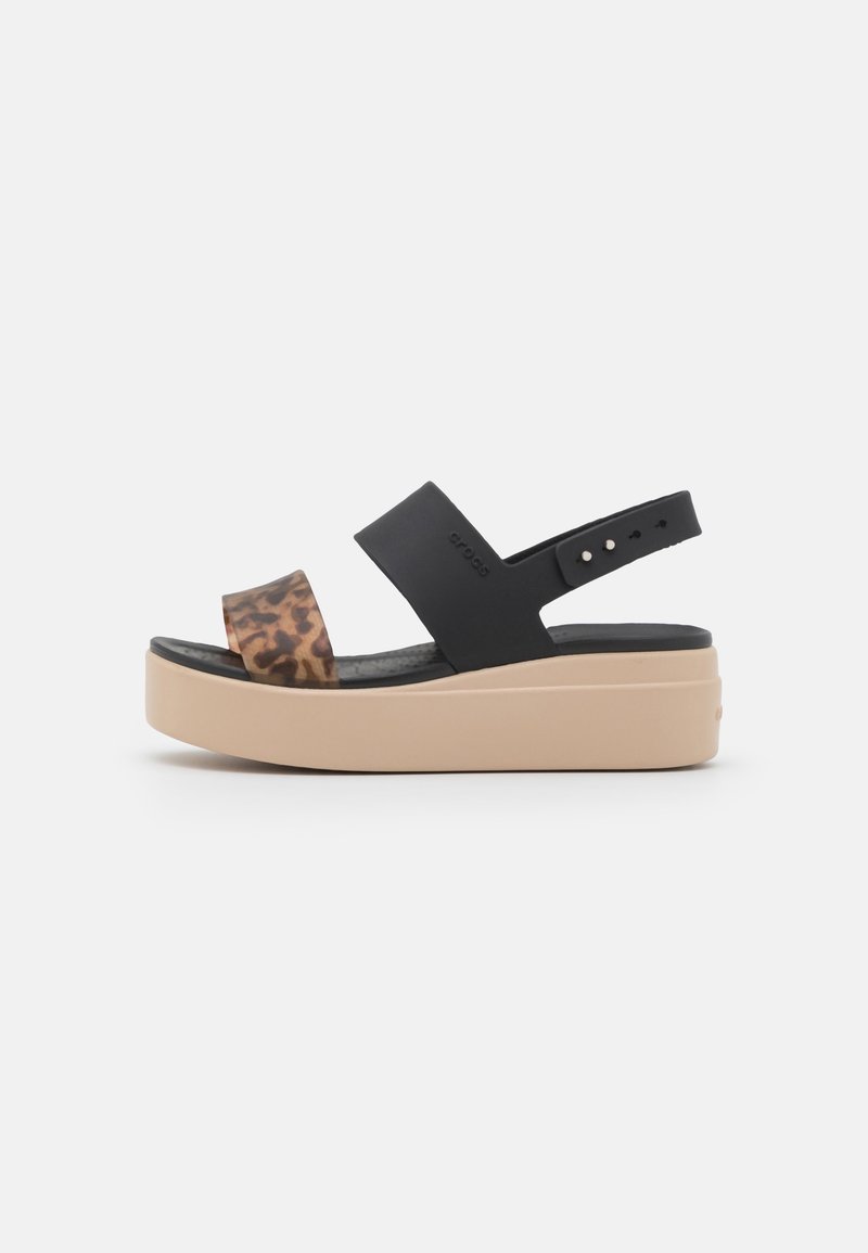 Sandale plateforme avec semelle beige, bride médiane noire et bride avant à imprimé léopard, avec bride de cheville noire réglable.
