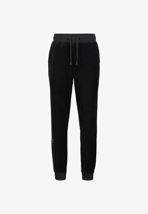 Black velour joggers with a ribbed waistband and cuffs, featuring a drawstring and a small logo detail on the lower side.