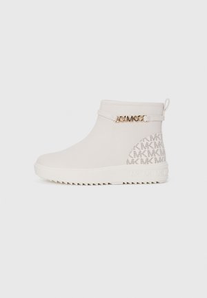 Botas blancas de tobillo hechas de material texturizado, con un acento de cadena dorada y un detalle de logo estampado en la parte trasera. Suela de goma flexible.