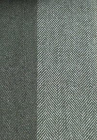 Stof met visgraatpatroon in donker groen en lichtgrijs, met een gestructureerd en geweven uiterlijk.
