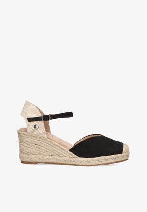 Wedge de esparto negro de ante con suela de yute trenzado, con una correa de tela beige en el tobillo y hebilla ajustable. Diseño de punta redonda.