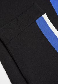 Czarna tkanina sportowa o gładkiej fakturze, z niebieskimi i białymi paskami po bokach dla dodatkowego wykończenia.