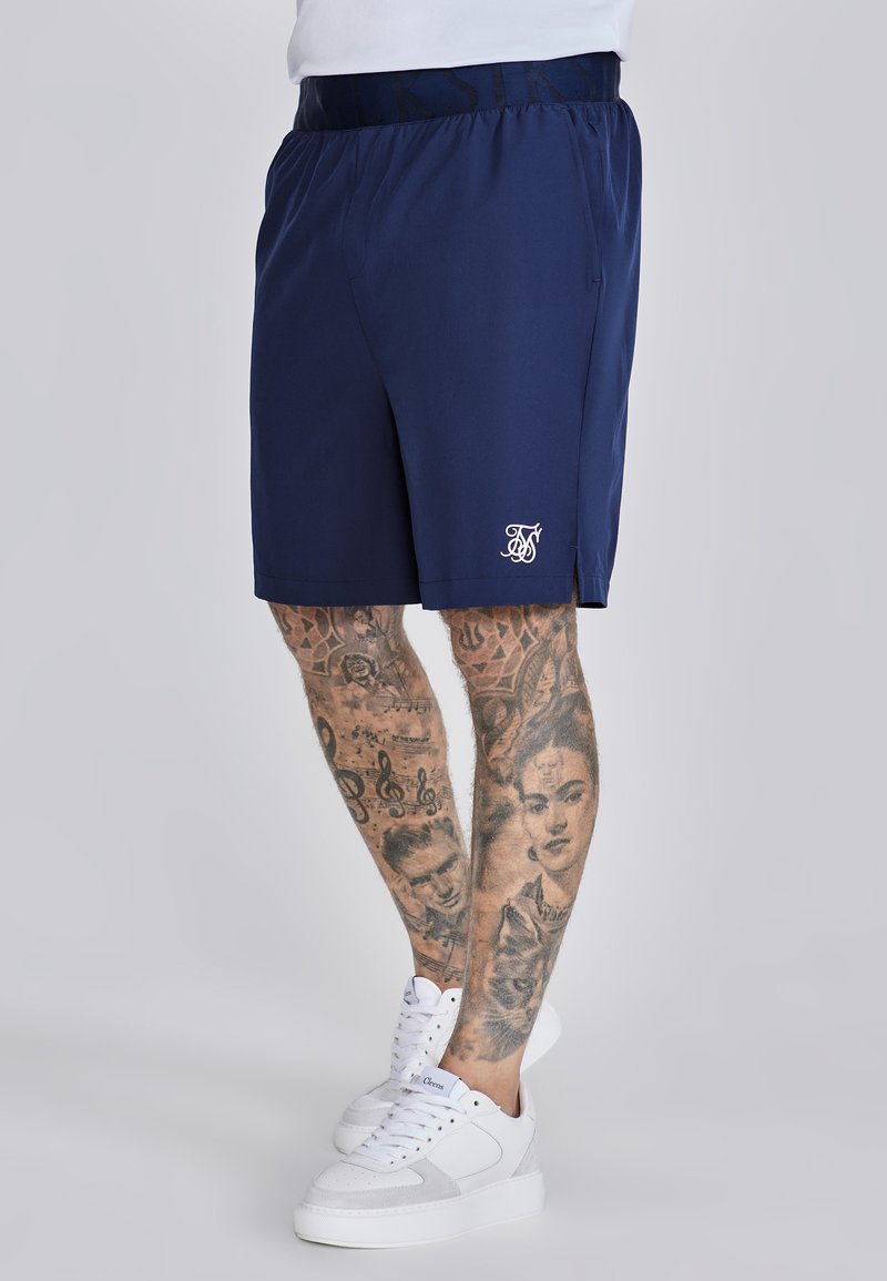 Pantaloni sportivi navy con elastico in vita, dotati di logo bianco sull'orlo e tasche laterali. Tessuto morbido e leggero.