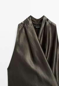 Sleeveless, dark olive green top made of smooth, shiny fabric; features a draped neckline and a relaxed fit.