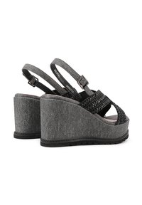 Sandali wedge grigi con trama denim, punta aperta e dettagli intrecciati neri. Cinghie regolabili e suola in gomma testurizzata.