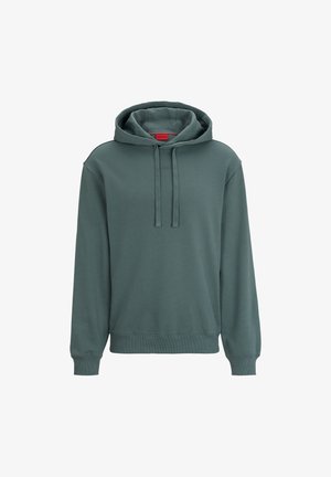 Sweat à capuche vert foncé avec manches longues, poche avant, cordons et étiquette rouge à l'intérieur du col.