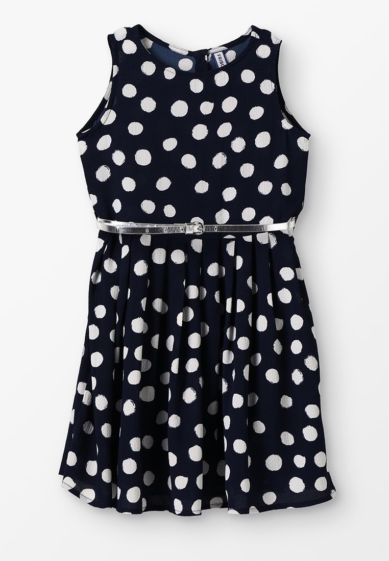 Robe sans manches bleu marine à pois blancs avec ceinture fine argentée à la taille, jupe plissée, encolure ronde.