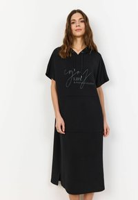 Schwarzes Kapuzenkleid mit kurzen Ärmeln, ausgestattet mit einer Fronttasche und weißem Drucktext, glatte Textur und lässiger Schnitt.