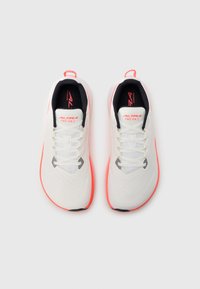 Αθλητικά παπούτσια με λευκό εξωτερικό από δίχτυ με κόκκινες λεπτομέρειες, στρογγυλεμένη μύτη και υφασμένα πέλματα για βελτιωμένη πρόσφυση. Ελαφρύ σχέδιο.