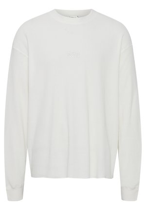 Hvit langermet skjorte med ribbet tekstur, rund hals og subtilt hvitt brodert 'ABC'-logo på brystet. Løs passform med innsvingte mansjetter.