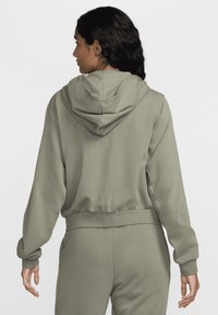 Felpa corta verde oliva realizzata in tessuto morbido, con cappuccio foderato e polsini a coste, progettata per una vestibilità comoda.