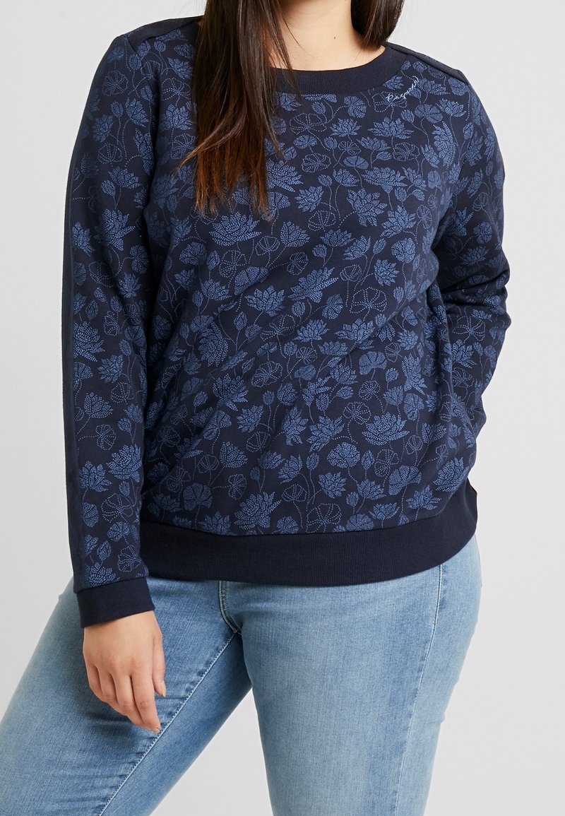 Sudadera azul marino con estampado floral en un tono azul más claro. Presenta un cuello redondo y puños y dobladillo acanalados. Tejido suave, corte relajado.