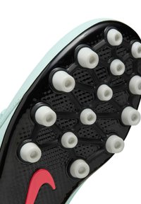 Des crampons avec une tige vert menthe, une semelle texturée noire et des crampons blancs. Présente un grand swoosh rouge sur le côté.