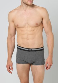 Boxers listrados em preto e cinza com um cós elástico. O tecido parece suave com um design ajustado, apresentando um logo da marca no cós.