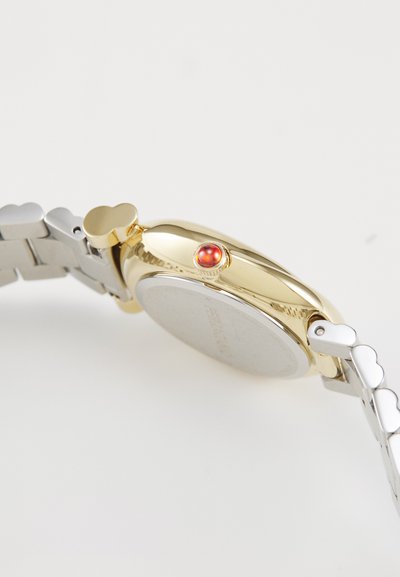 Montre en or et argent avec un boîtier rond, bouton d'accent rouge et maillons en forme de cœur sur le bracelet. Surface métallique lisse, très peu de détails.