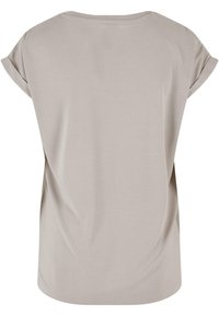 Lys beige kortærmet top lavet af blødt stof. Har en rund hals og en løs pasform med subtil drapering bagpå.