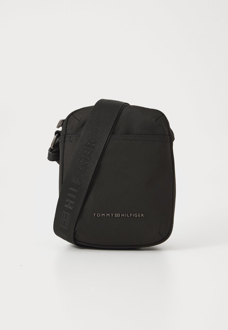 Must musta ristkotiga kott, millel on ristkülikukujuline kuju, eespool tõmblukuga tasku ja reguleeritav rihm. Logo on eespool reljeefselt kujundatud.