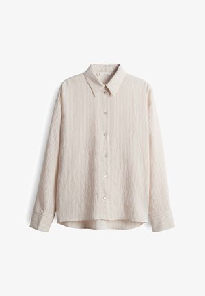 Camicia a maniche lunghe leggera color beige chiaro con un motivo a righe testurizzato, colletto a punte e chiusura frontale con sei bottoni. Tessuto misto cotone.