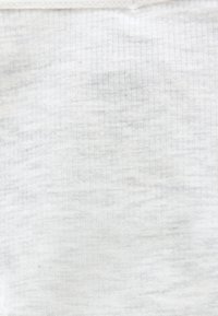 Κοντινή άποψη λευκού υφάσματος με ρίγες και οριζόντια ραφή κοντά στην πάνω άκρη.