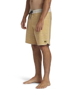Pantaloni da bagno gialli a fantasia con strisce orizzontali e motivi a rombo, dotati di vita con cordoncino e tasca laterale, realizzati in tessuto leggero.