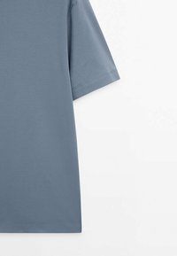 T-shirt bleu à manches courtes avec des coutures nettes et simples sur les manches et l'ourlet, présenté sur un fond blanc uni.