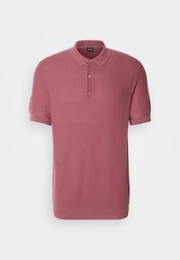 Polo en maille rose à manches courtes, avec trois boutons et un col pointu, présenté sur un fond blanc uni.
