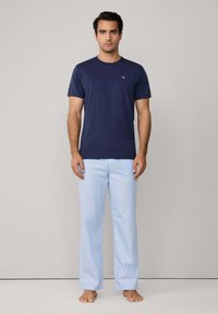 Námořnická modrá bavlněná tričko s krátkým rukávem, doplněné o světle modré bavlněné pyžamové kalhoty. Jednoduchý design, žádné viditelné vzory nebo akcenty.