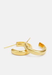Goldene Creolen mit einer glatten, glänzenden Oberfläche; kreisförmige Form mit schlankem Profil und dünnem Stecker zum Befestigen.