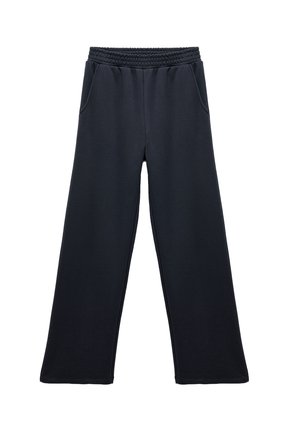 Pantalones deportivos de pierna ancha negros con una cintura elástica, dos bolsillos laterales y una textura suave. Diseño simple, sin patrones ni acentos visibles.