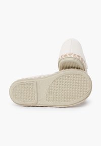 Scarpe slip-on in tela di colore bianco sporco con un accento intrecciato sul tallone e suola in gomma testurizzata con grip a motivo.