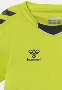 Jersey deportivo amarillo neón con escote en V. Logo negro y acentos en los hombros. Hecho de una tela suave y ligera, adecuada para ropa deportiva.