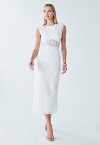 Bílé midi šaty z krajky s přiléhavým siluetou, krátkými rukávy a průsvitnou krajkovou panelem přes pas. Hladká textura a elegantní design.