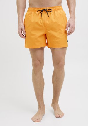 Maillots de bain orange avec une taille élastique et un cordon noir. Tissu lisse, longueur genou, avec un petit logo sur le côté.