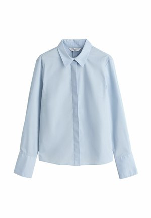 Camicia a maniche lunghe azzurro chiaro in tessuto liscio, con colletto a punta, chiusura frontale con bottoni e vestibilità leggermente aderente.