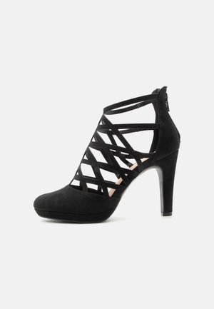 Svart damehøye hæler med lukket tå, platåsåle og kryssende stroppedesign, med glidelås bak.