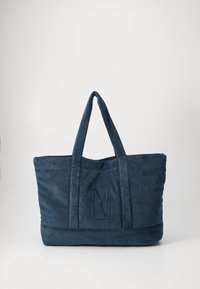 Navy blue tote bag made of textured fabric with two handles and a stitched logo prominently displayed on the front.