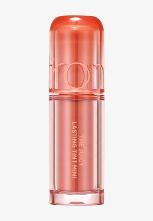 Petit contenant cylindrique pour baume à lèvres de couleur corail translucide avec le texte « The Juicy Lasting Tint Mini » sur le corps.