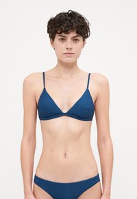 Set bikini a righe di colore blu navy, composto da un top triangolare con spalline sottili e slip coordinati a vita bassa, realizzati in un tessuto liscio e strutturato.