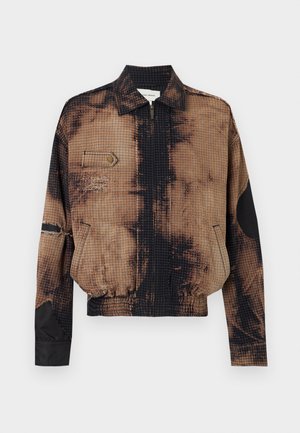 Veste zippée à carreaux marron et noir avec col, poche poitrine à rabat, ourlet élastique et renforts noirs aux coudes sur les manches.