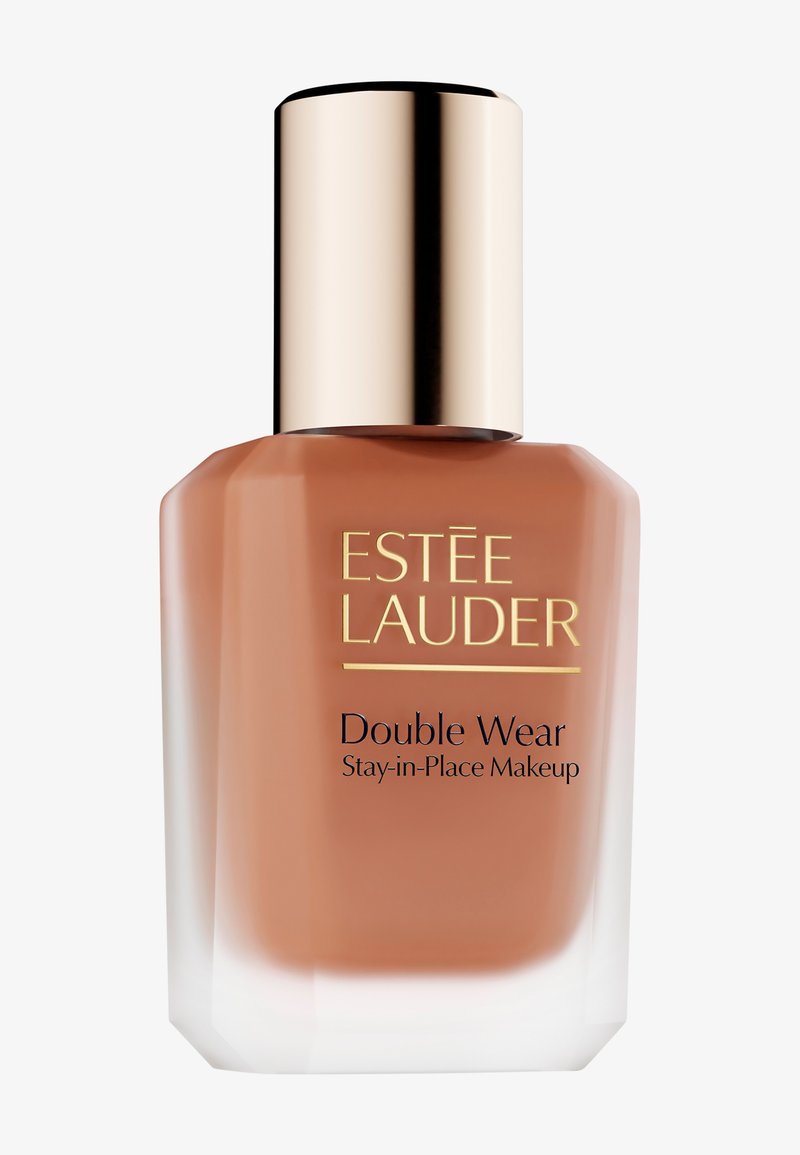 Fond de teint Estée Lauder Double Wear dans un flacon transparent contenant un liquide marron. Le bouchon est métallique doré et cylindrique. Présente une étiquette noire.