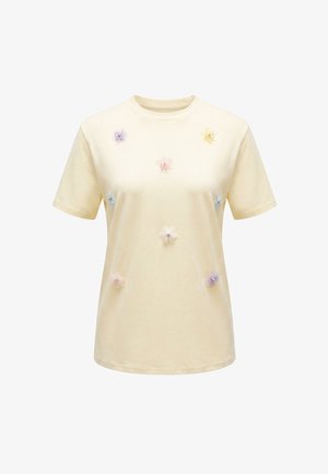 Lysgul kortærmet t-shirt dekoreret med små pastelfarvede stofblomster fordelt på forsiden.