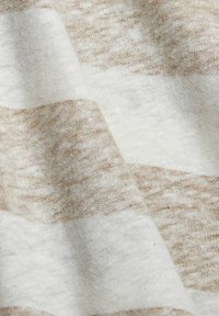 Tejido ligero con rayas alternas en beige y blanco roto, que presenta una textura suave y sutiles variaciones de color.