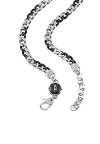 Collana a catena in argento e nero con grandi anelli, chiusura rotonda con logo e dettagli di catena regolabile.