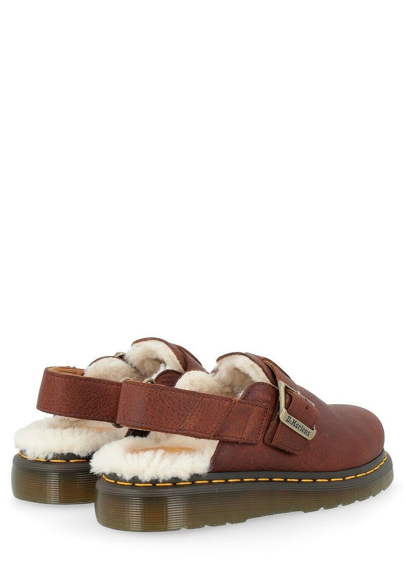 Chaussures à enfiler en cuir brun avec des brides réglables, doublure en fausse fourrure et une semelle en caoutchouc translucide épaisse ornée de surpiqûres jaunes.