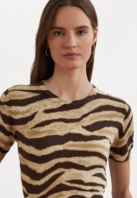 Top curto de mangas curtas em tons de castanho e bege, com um padrão de riscas de tigre, decote redondo e textura suave.