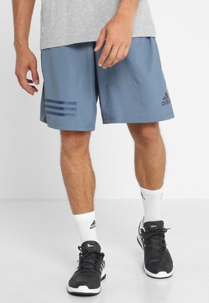 Męskie krótkie spodenki sportowe w jasnoniebieskim kolorze z trzema ciemnoniebieskimi paskami na lewej nogawce. Posiadają elastyczny pas i lekką tkaninę.