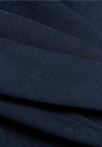 Tela de algodón azul marino con una textura lisa, que presenta capas dobladas que resaltan su tejido duradero y color uniforme.