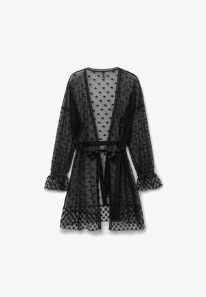 Bata negra transparente con malla de corazones, mangas largas, puños fruncidos y lazo de satén en la cintura, mostrada sobre un fondo blanco.