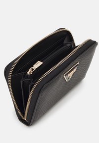 Black wallet with a textured surface, gold metal zipper, and a signature logo plate. Inside compartments include a zippered pocket and card slots.